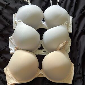 3 Victoria’s Secret adjustable strap bras 38C. 2 white, 1 beige.